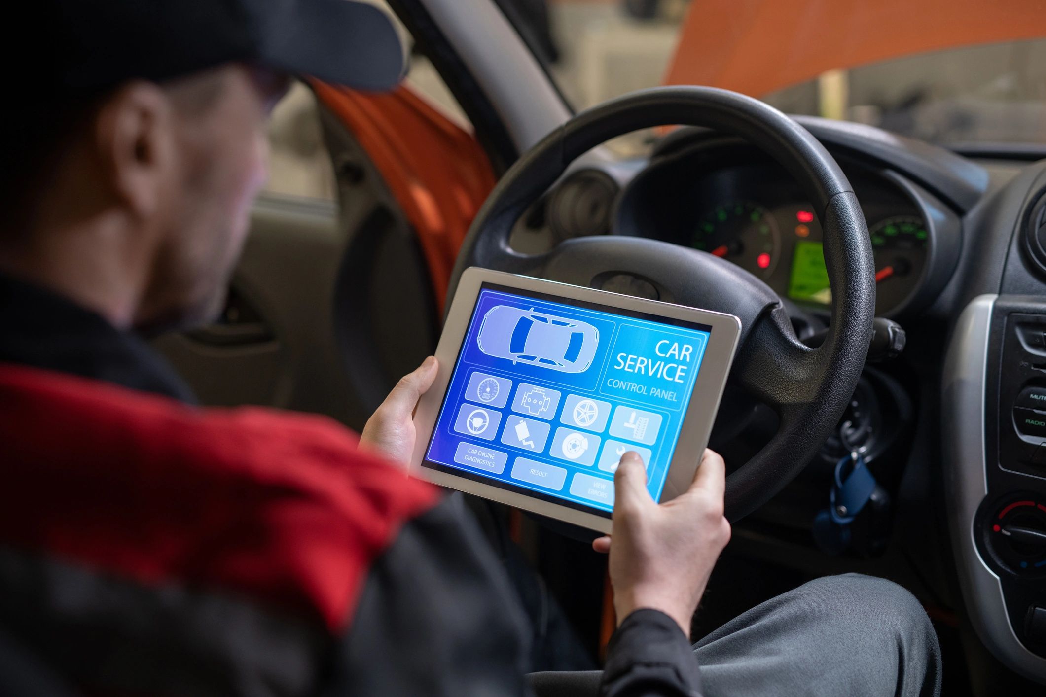 Technician using a tablet to review a vehicle service check