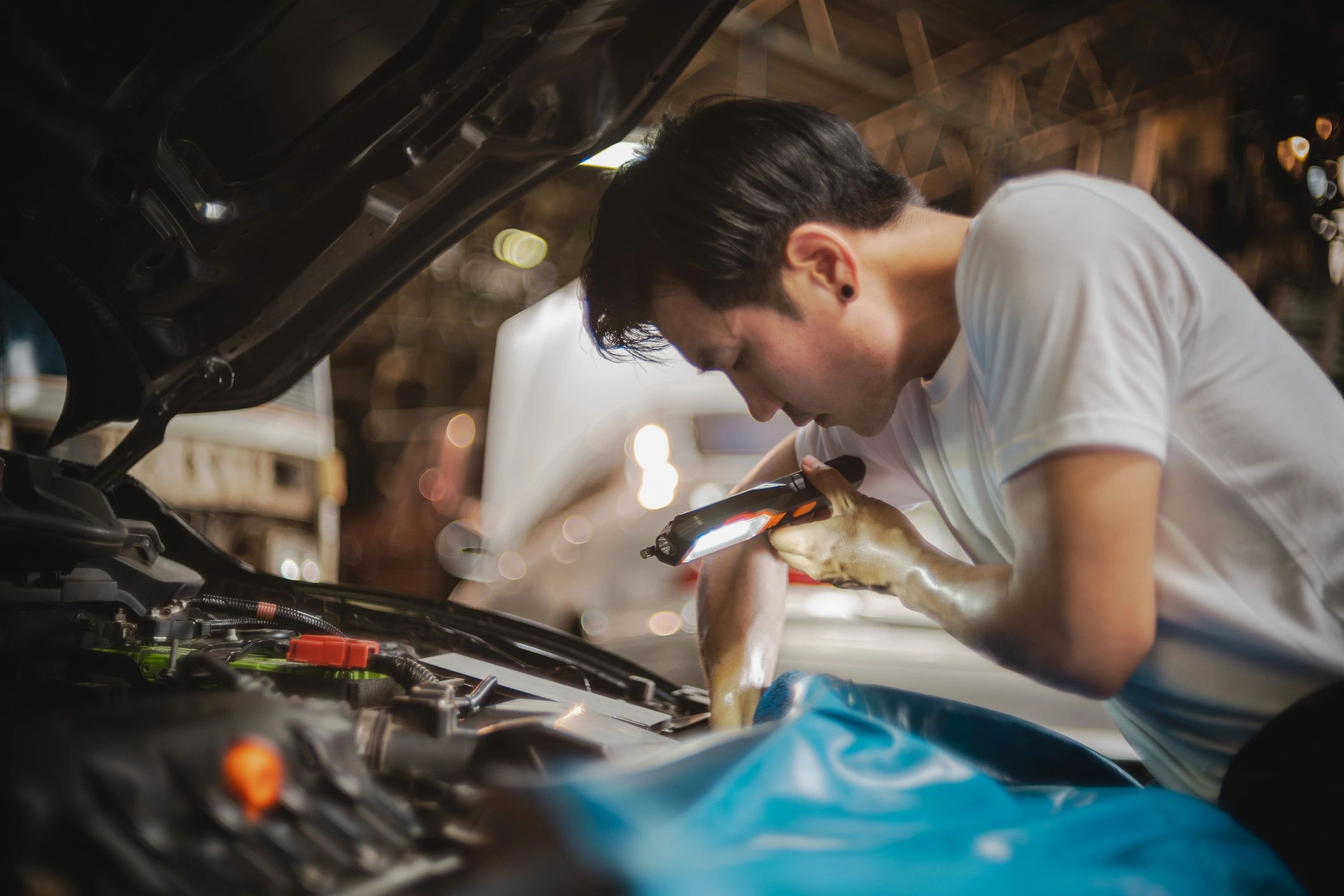 Technician inspecting a car engine bay during a diagnostic check