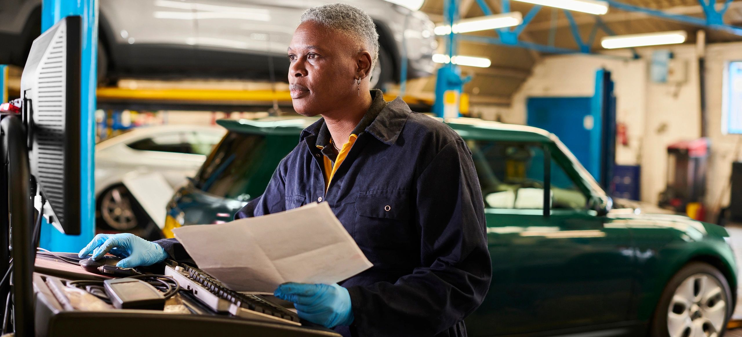 Technician reviewing transmission service data on a computer in an auto shop