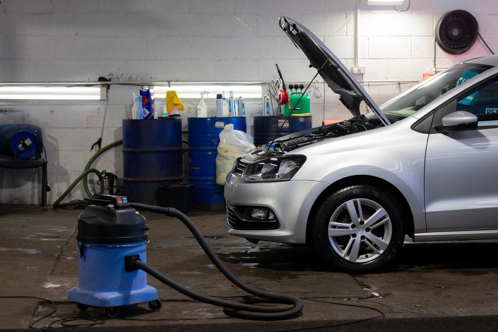 Silver car being serviced in a clean auto shop